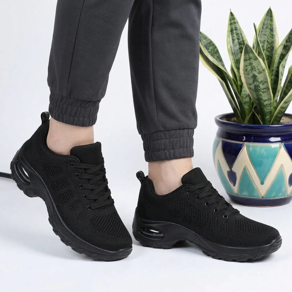 HexoComfy™ Men's Orthopedic High-Support Shoes in Black worn with joggers beside a plant