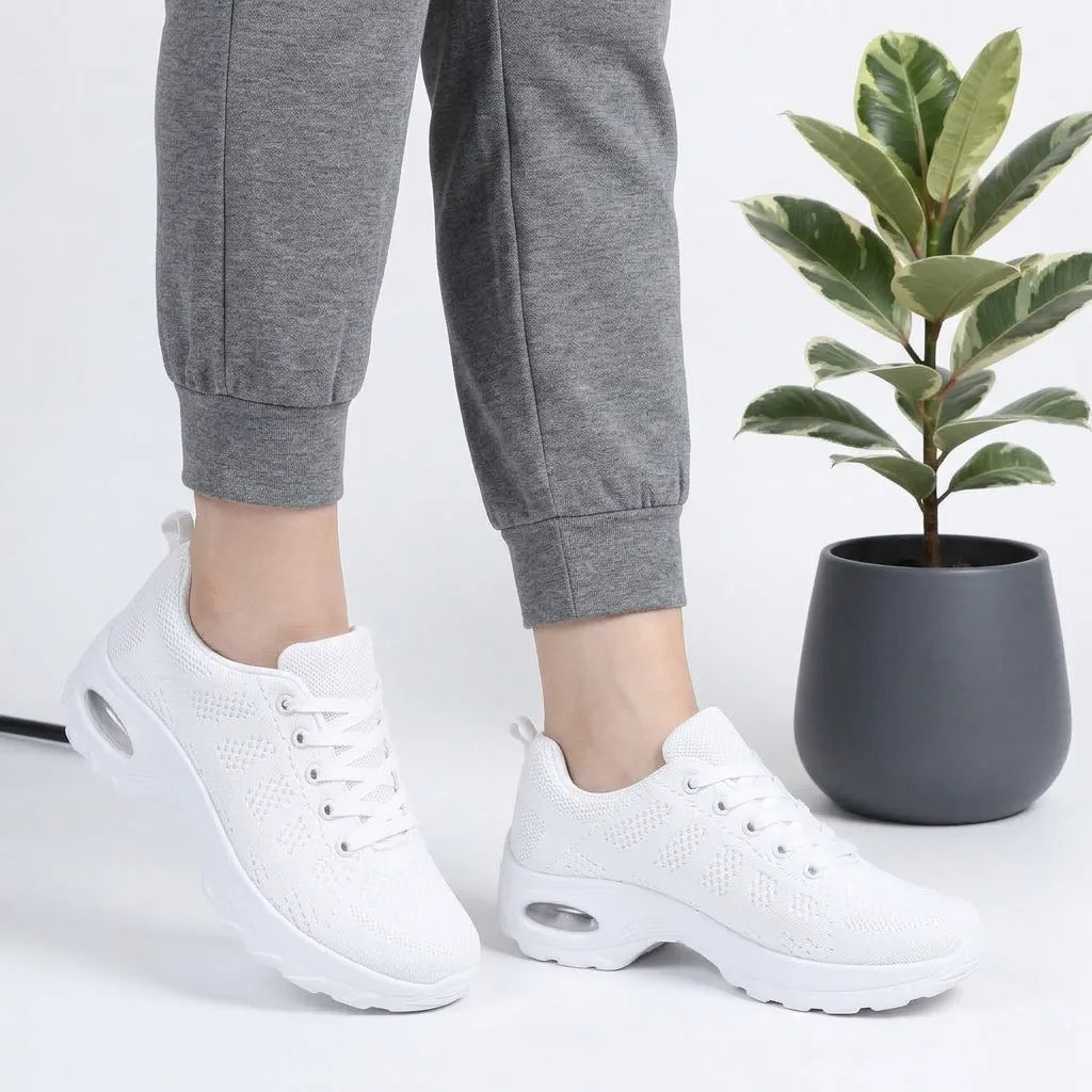 HexoComfy™ Men's Orthopedic High-Support Shoes in White worn with gray joggers beside a plant
